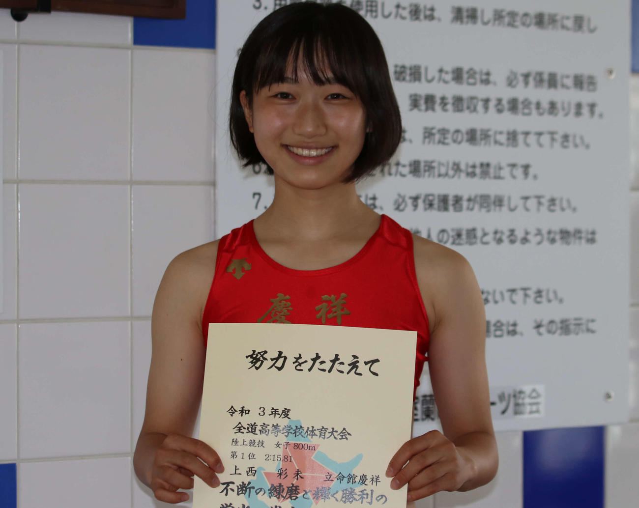女子800メートルで優勝を決め、賞状を手に笑顔をみせる立命館慶祥の上西（撮影・山崎純一）