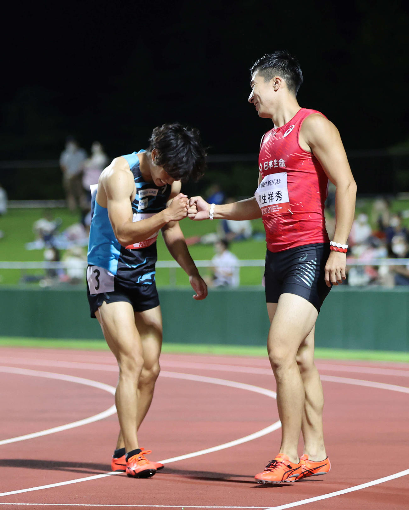 男子100メートルを制した桐生（右）は2位の坂井とグータッチをかわす（撮影・河野匠）