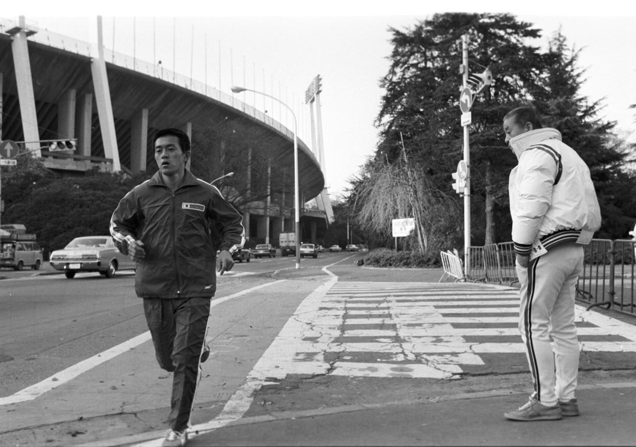 宗兄弟と死闘の末、福岡国際マラソン2連覇を飾った瀬古利彦（左＝早大4年）は、一夜明けのこの日もモスクワ五輪に向け中村清監督（右）の見守る中、神宮外苑コースを走り込む（1979年12月3日撮影）