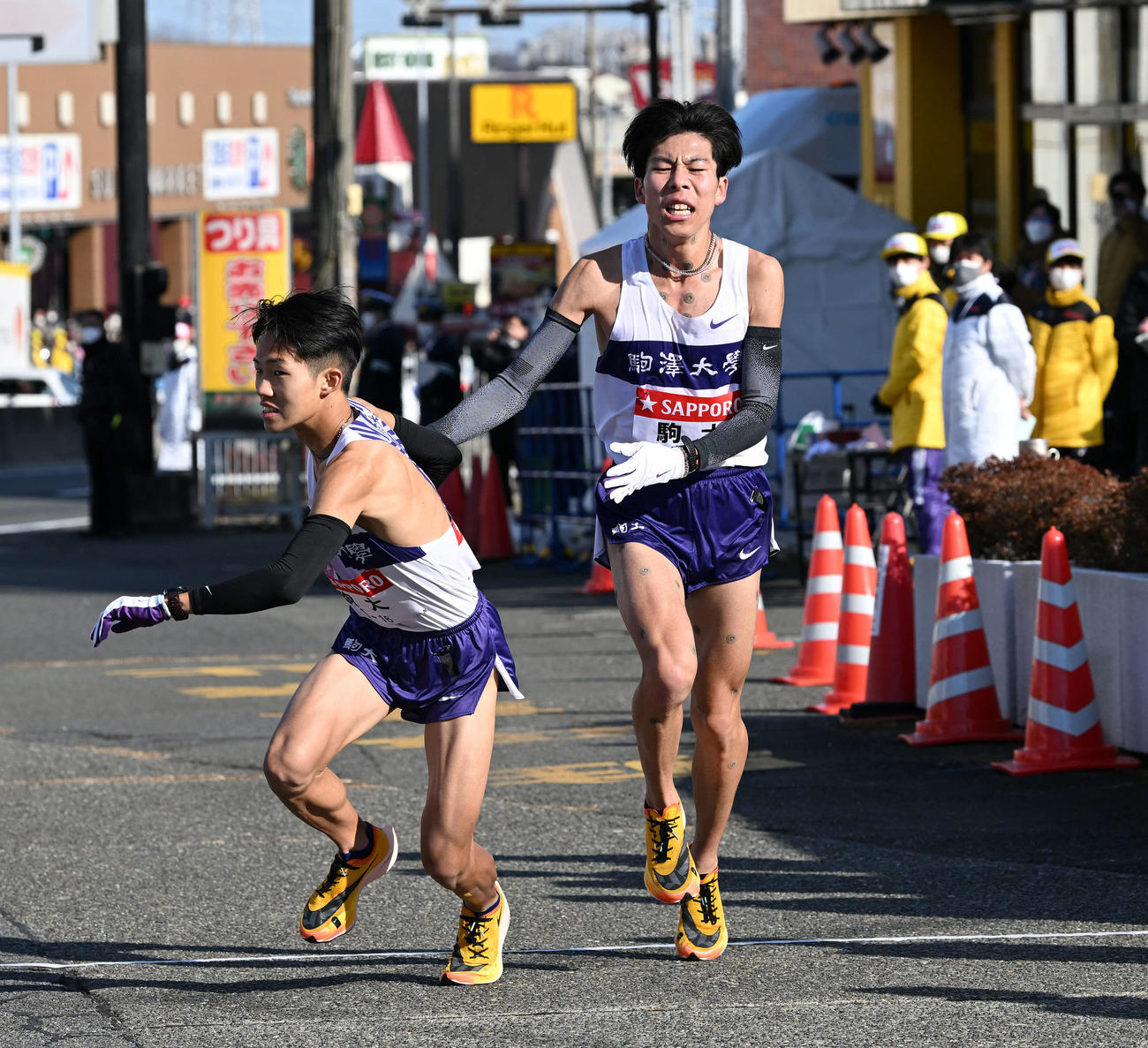 戸塚中継所で駒大2区田沢（右）は3区安原にたすきを渡す（撮影・滝沢徹郎）