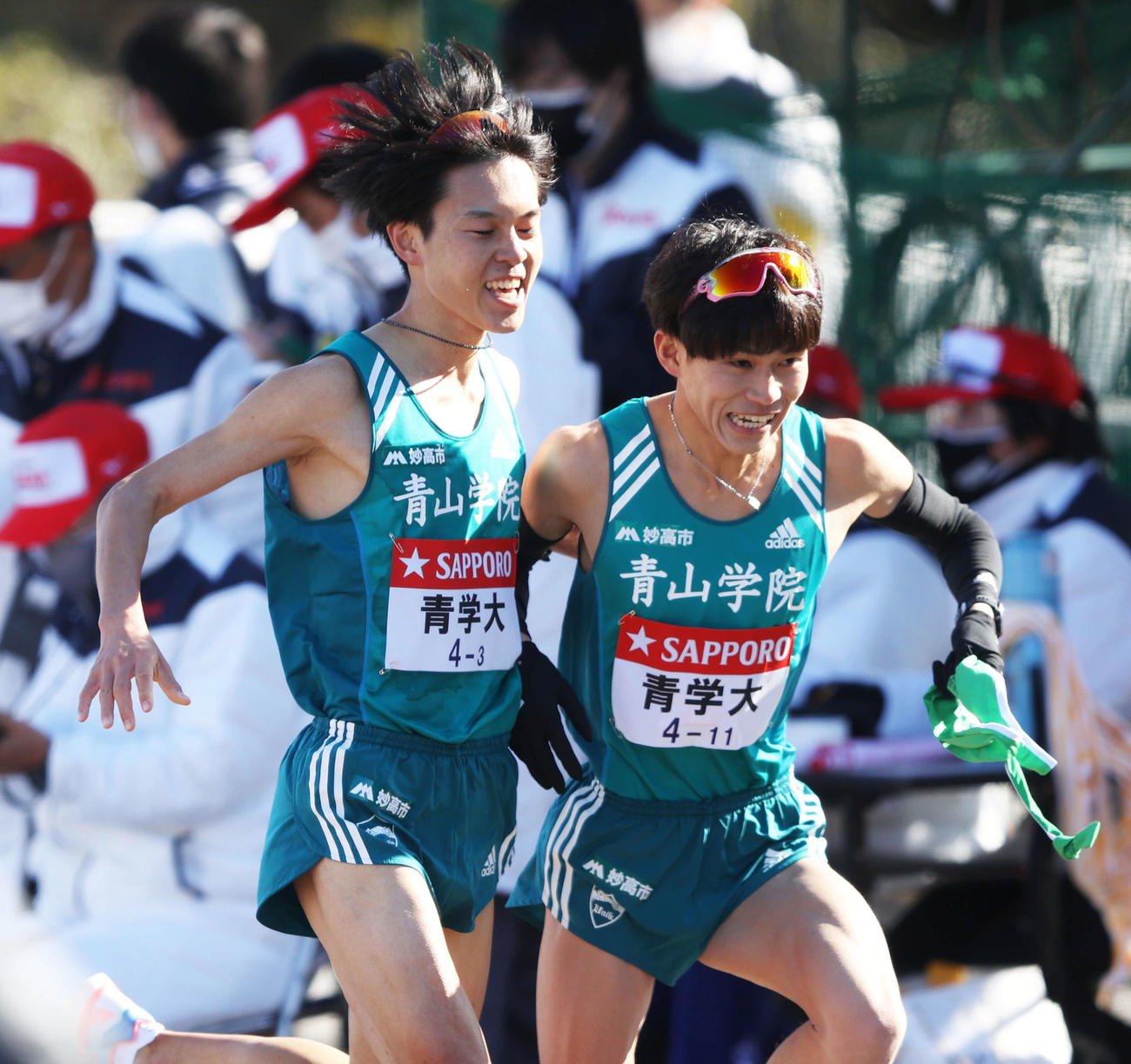 平塚中継所を1位でタスキリレーする青学大3区太田（左）と4区飯田（撮影・河田真司）