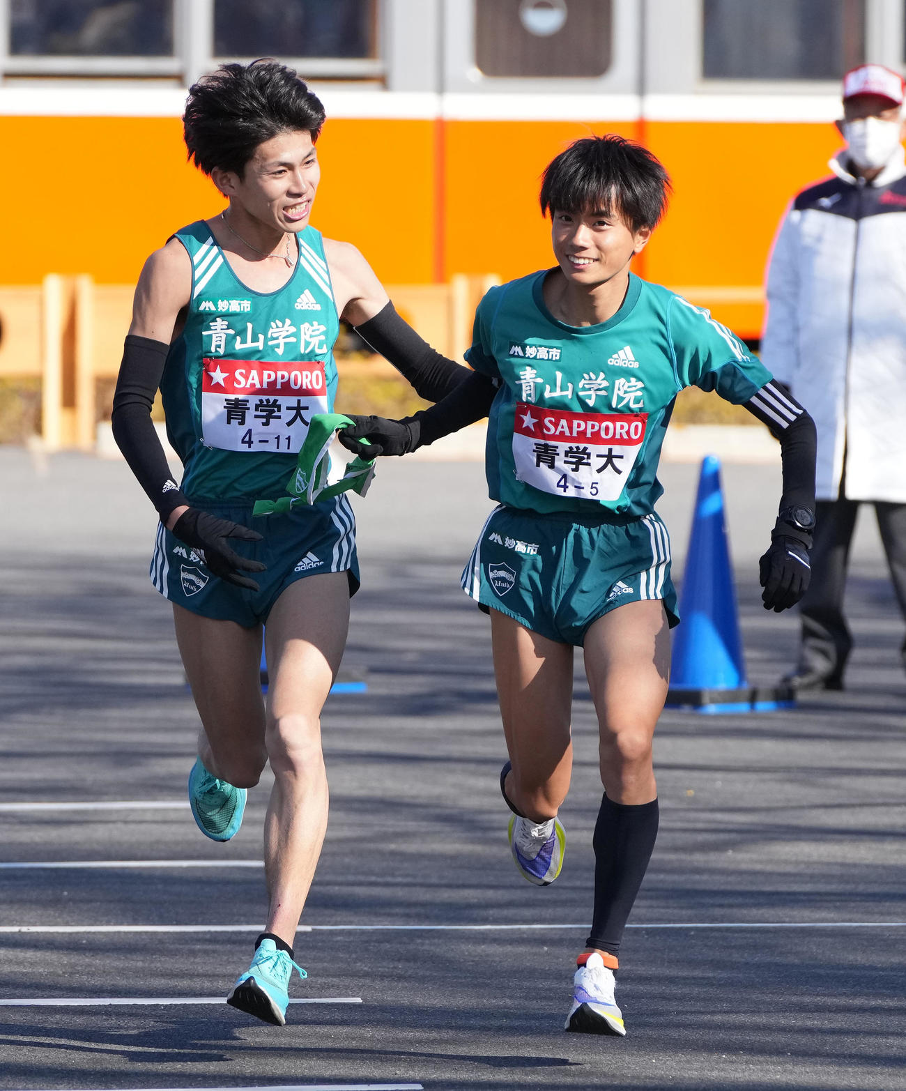 青学大4区飯田（左）は小田原中継所トップで5区若林にたすきを渡す（撮影・鈴木みどり）