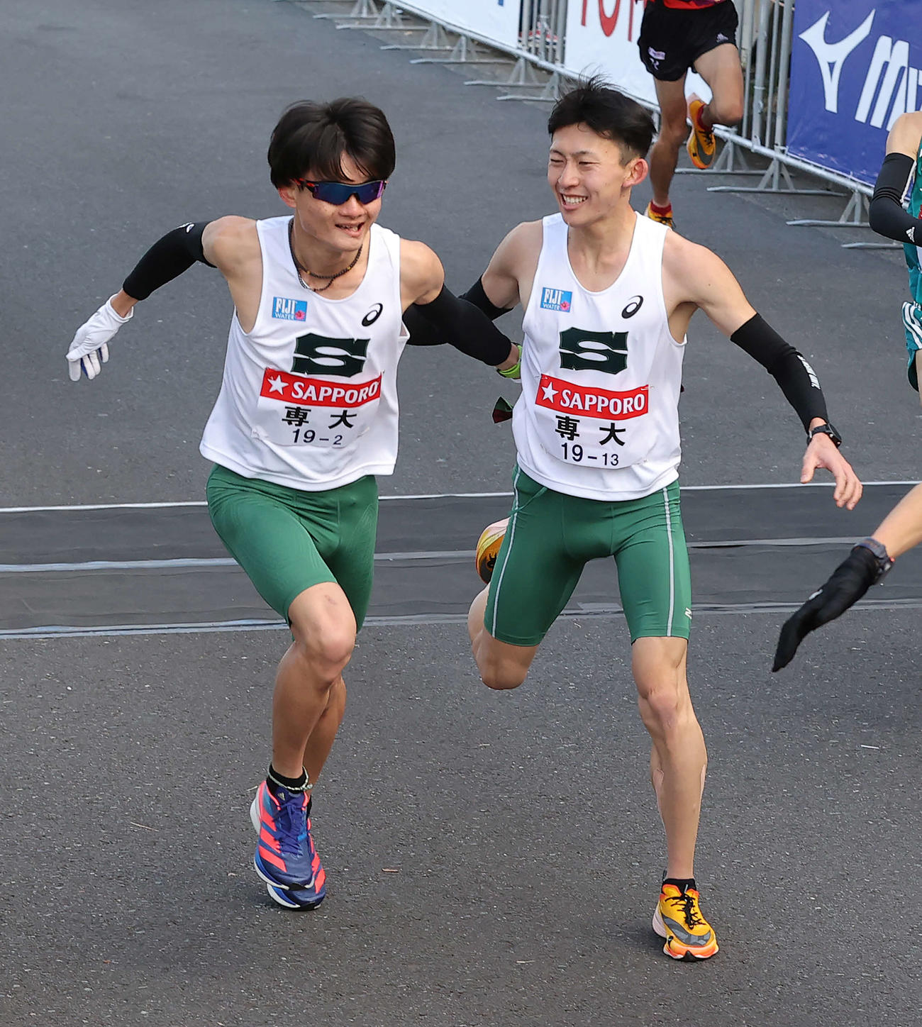 鶴見中継所、4位でたすきをつなぐ専大1区木村（右）と2区高瀬（撮影・河野匠）