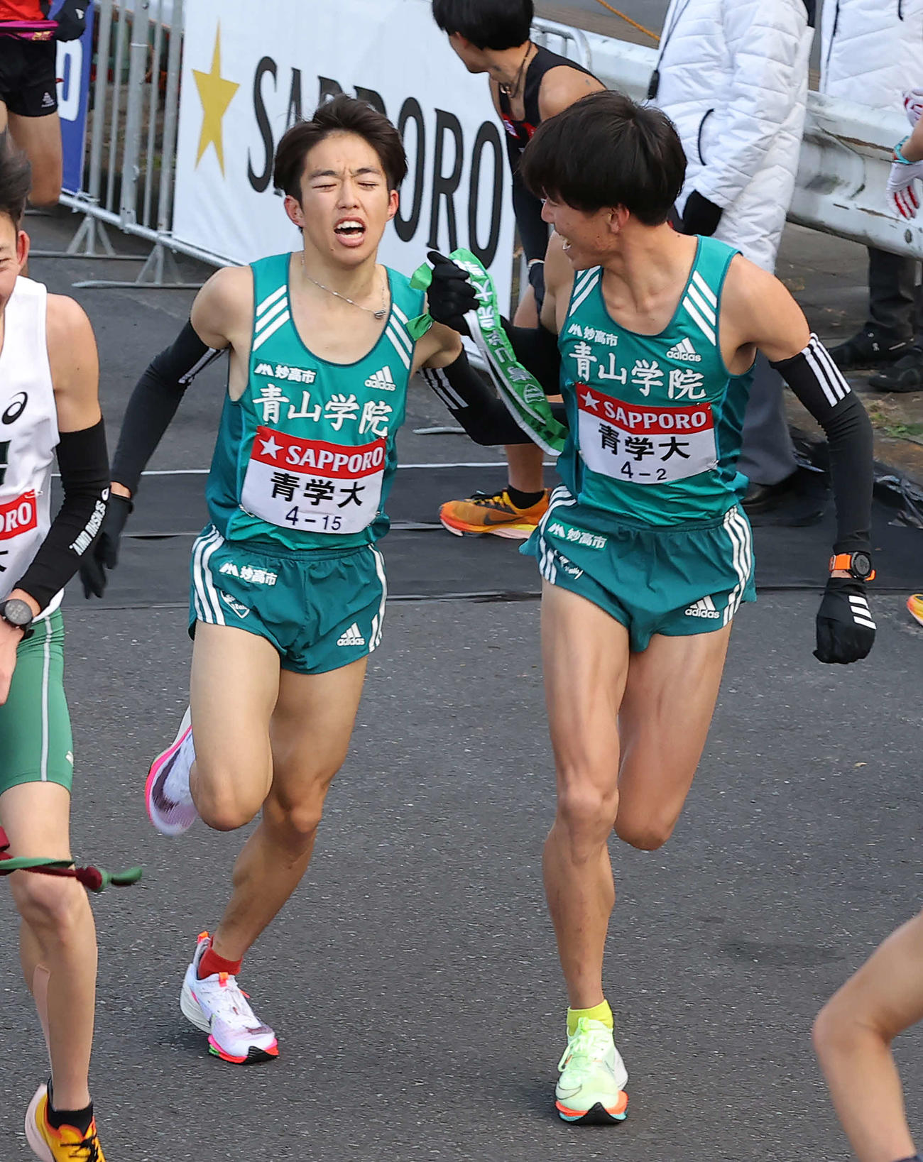 鶴見中継所、5位でたすきをつなぐ青学大1区志貴（左）と2区近藤（撮影・河野匠）