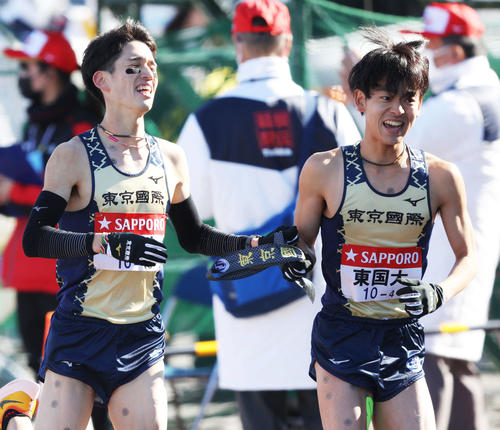 平塚中継所を2位でタスキリレーする東京国際大3区丹所（左）と4区堀畑（撮影・河田真司）