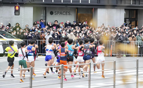 第98回箱根駅伝往路1区　一斉にスタートする選手たちに視線を送る通行人（撮影・菅敏）
