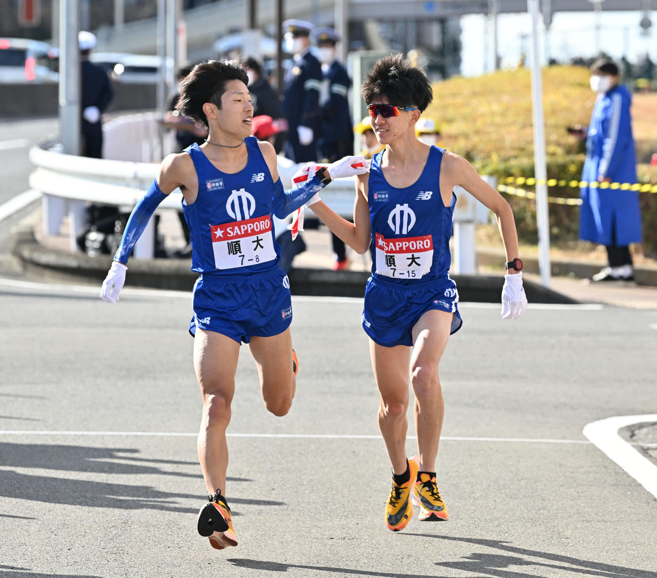 戸塚中継所で順大8区津田（左）は9区野村にたすきを渡す（撮影・滝沢徹郎）