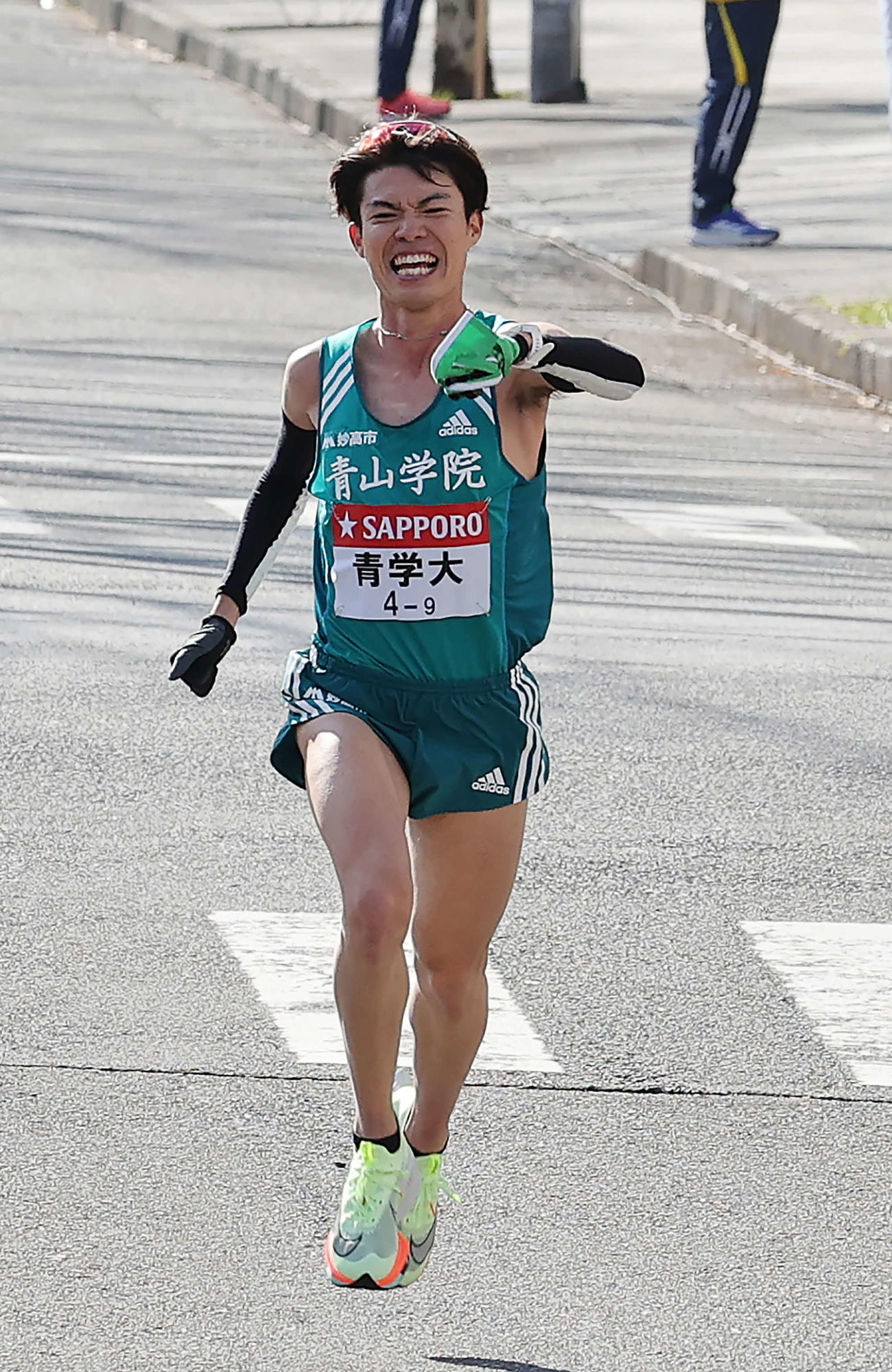 たすきを掲げながら鶴見中継所に向かう青学大9区中村（撮影・河野匠）