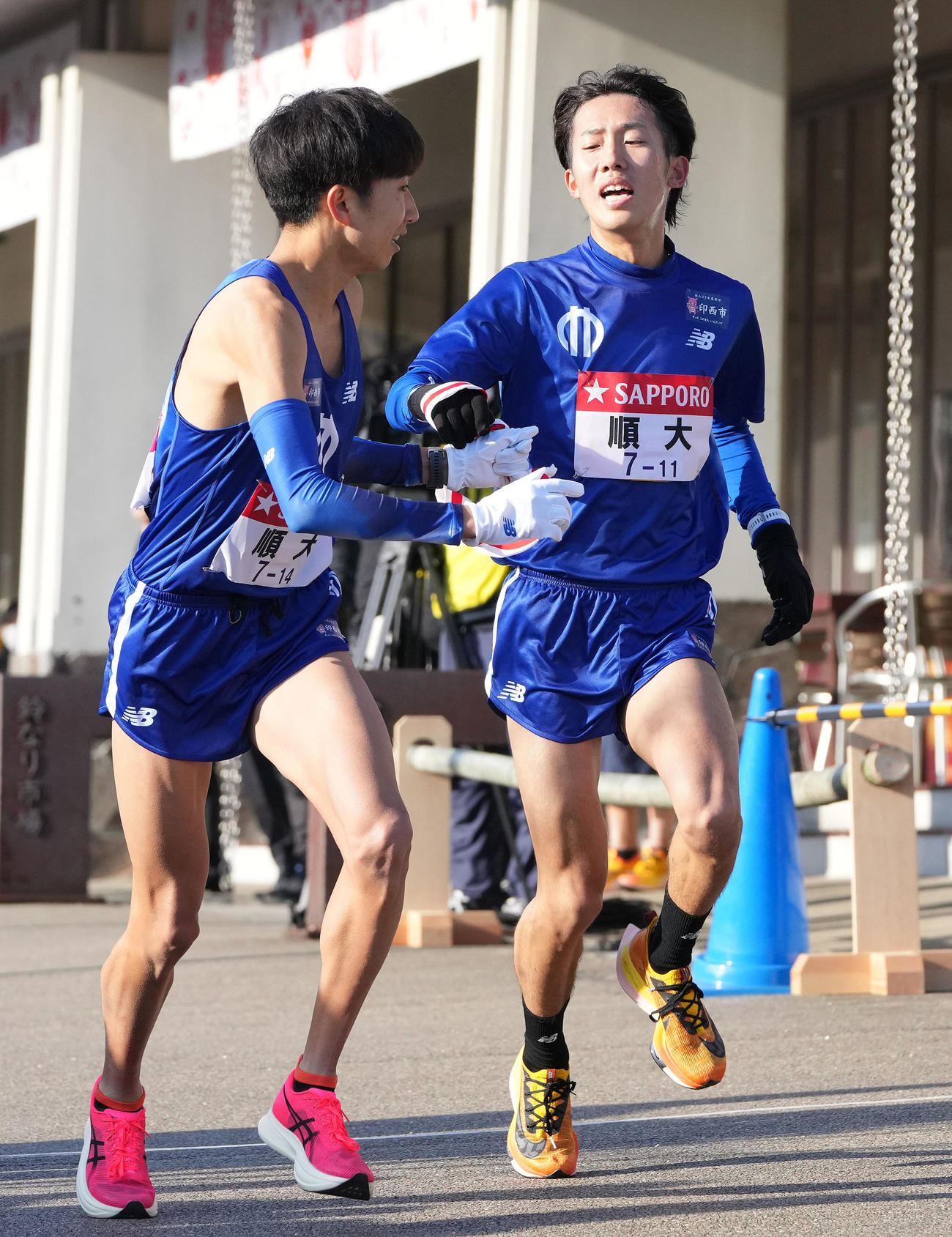 順大6区牧瀬（右）は小田原中継所で7区西沢にたすきを渡す（撮影・鈴木みどり）