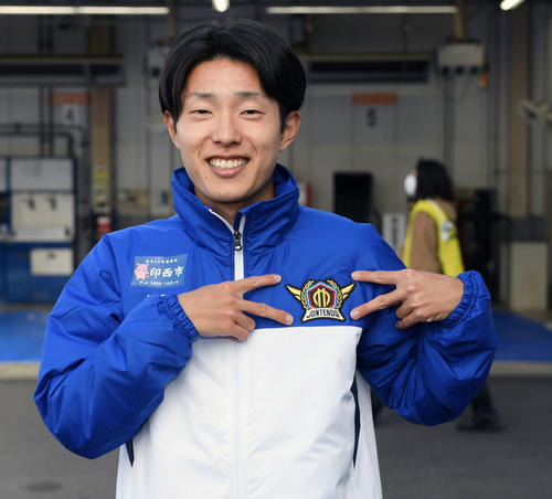 8区区間賞の順大・津田は笑顔でチームマークを指さす（撮影・滝沢徹郎）