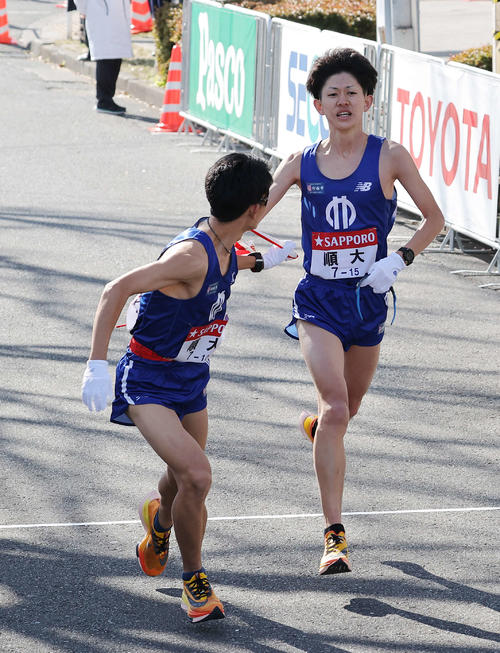 鶴見中継所、2位でたすきをつなぐ順大9区野村（右）と10区近藤（撮影・河野匠）