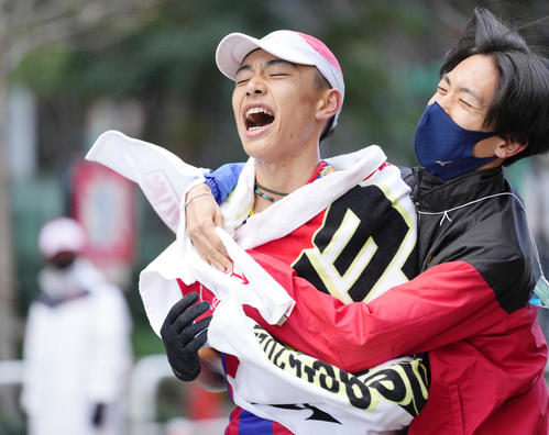 7位でゴールし、チームメイトに抱えられる創価大10区松田（撮影・菅敏）