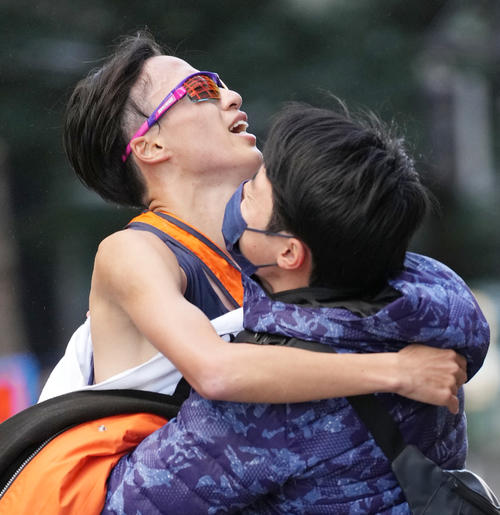 10位でゴールし、抱えられる法大10区川上（撮影・菅敏）