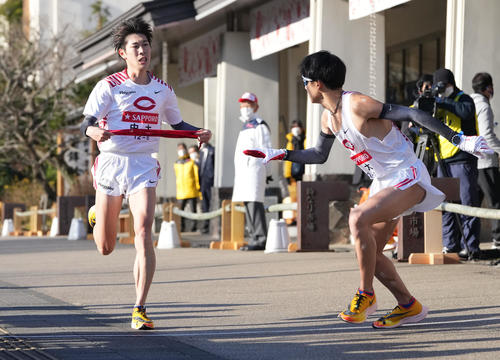 中大6区若林（左）は小田原中継所で7区居田にたすきを渡す（撮影・鈴木みどり）