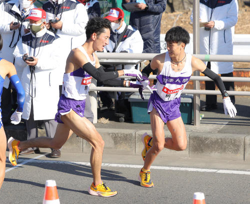 平塚中継所を2位でタスキリレーする駒大7区白鳥（左）と8区鈴木（撮影・河田真司）