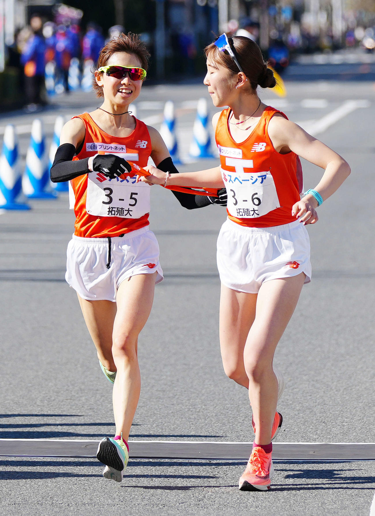 全日本大学女子選抜駅伝の第5中継所で6区拓大・梅木（右）にたすきを渡す5区の不破（撮影・江口和貴）