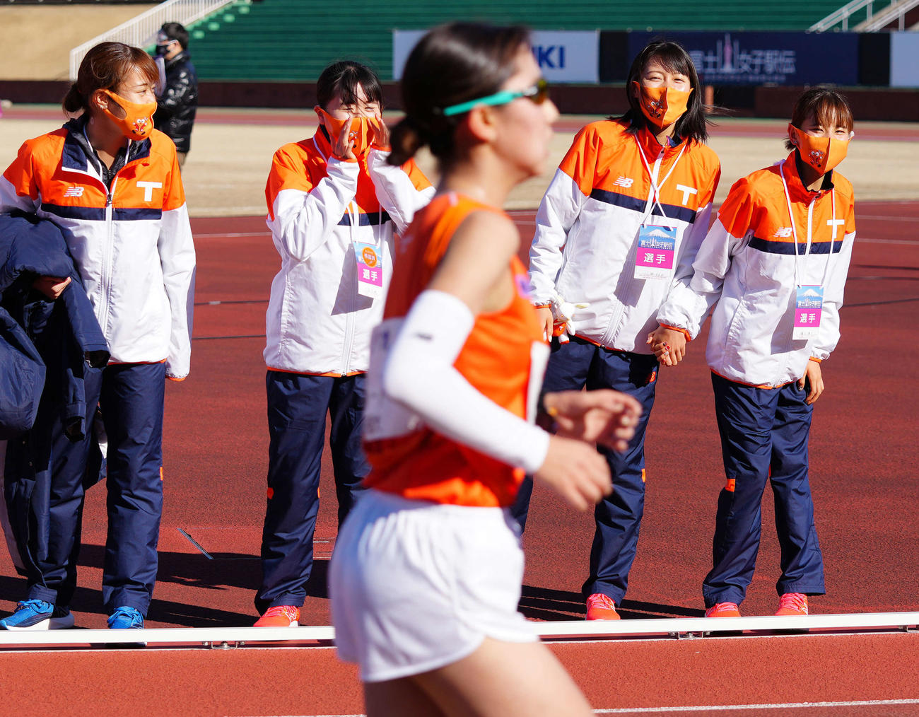 全日本大学女子選抜駅伝の7区で力走する伊井（手前）を応援する不破（右端）ら拓大の選手たち（撮影・江口和貴）