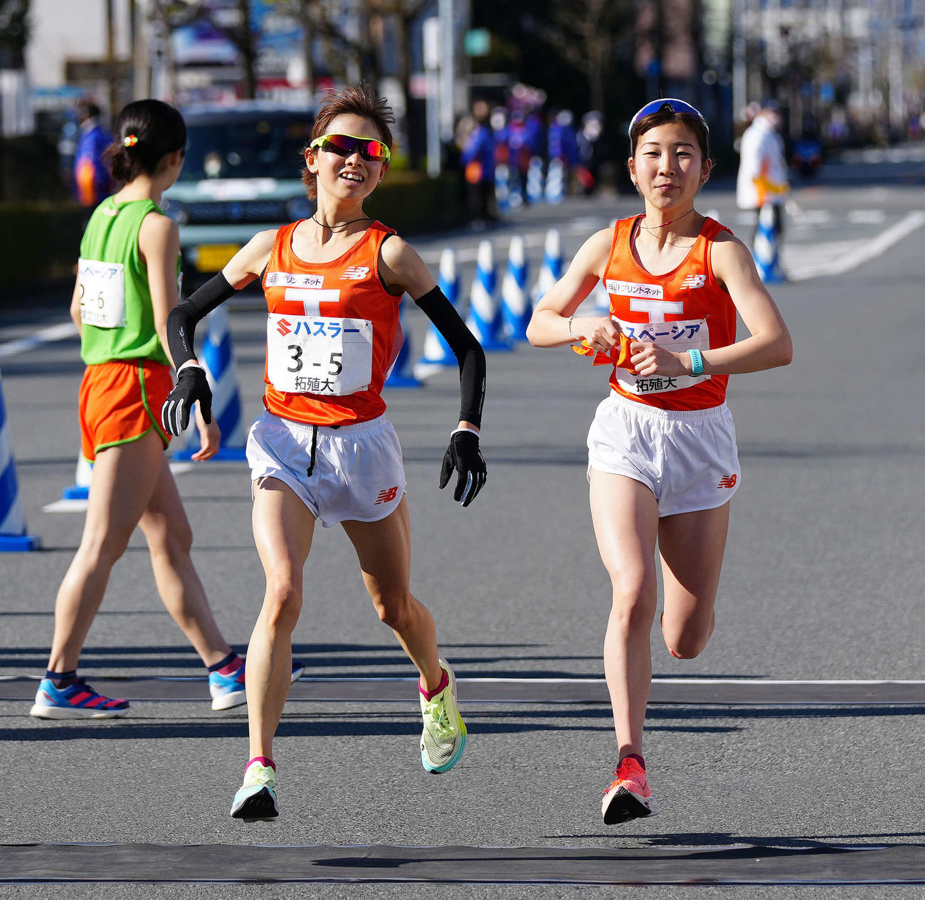 全日本大学女子選抜駅伝の第5中継所で6区拓大・梅木（右）にたすきを渡した5区の不破（撮影・江口和貴）