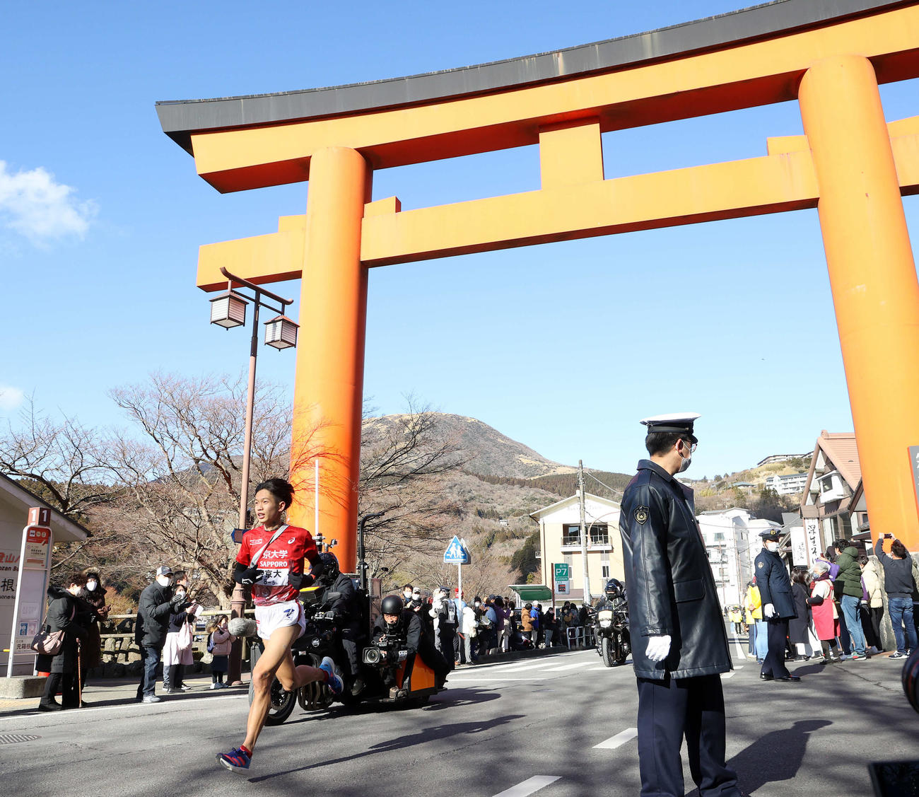 箱根神社の大鳥居を通過する帝京大5区細谷（撮影・鈴木正人）