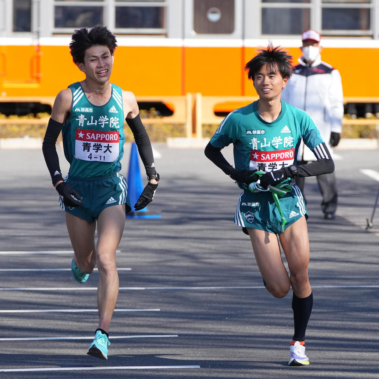 青学大4区飯田（左）は小田原中継所トップで5区若林にたすきを渡す（撮影・鈴木みどり）