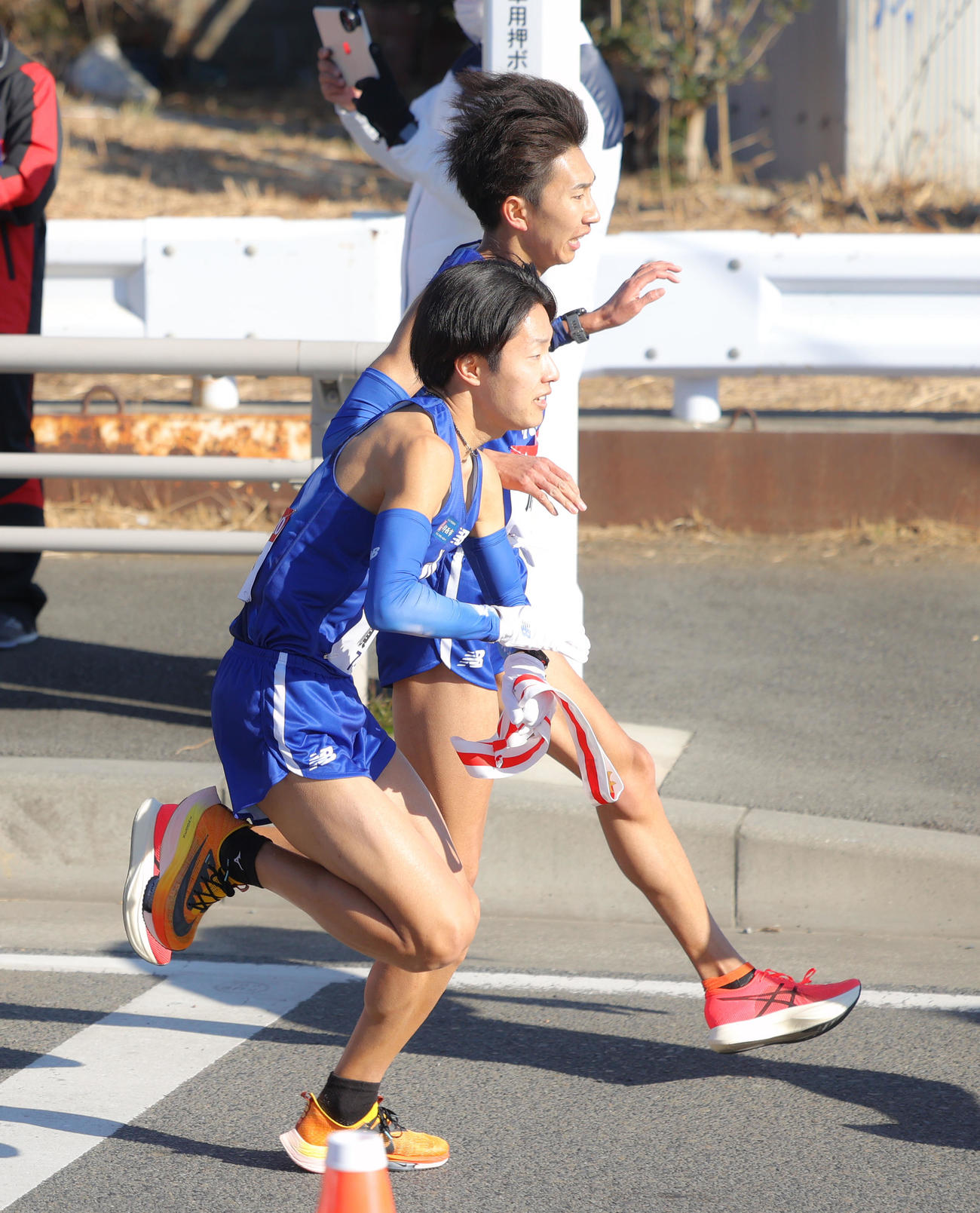 平塚中継所を3位でタスキリレーする順大7区西沢侑馬（奥）と8区津田将希（撮影・河田真司）