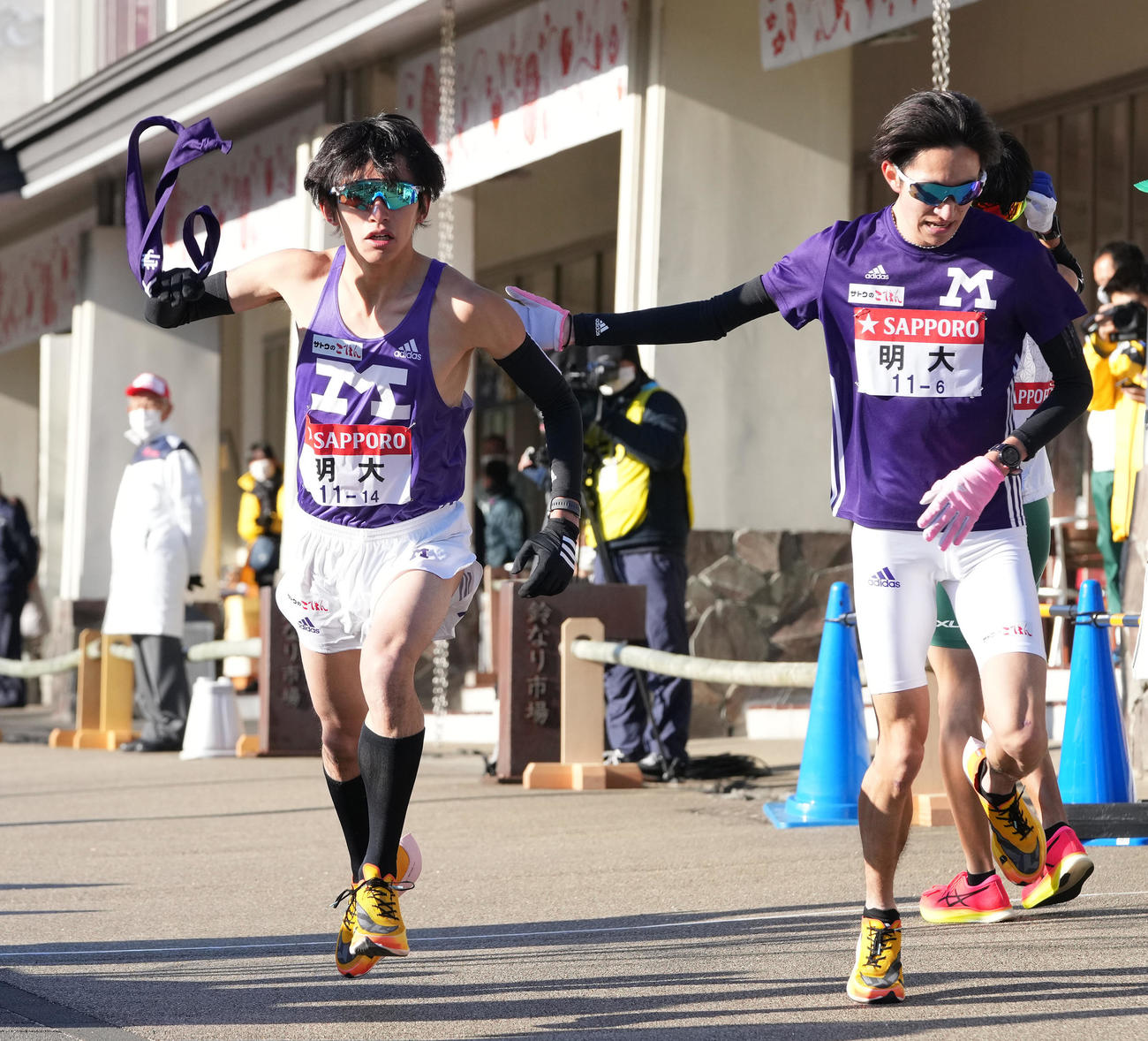 明大6区杉本（右）は小田原中継所で7区富田にたすきを渡す（撮影・鈴木みどり）