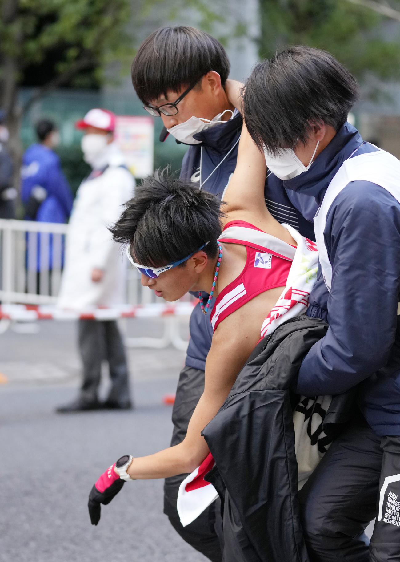 9位でゴールし、抱えられる帝京大10区西脇（中央）（撮影・菅敏）