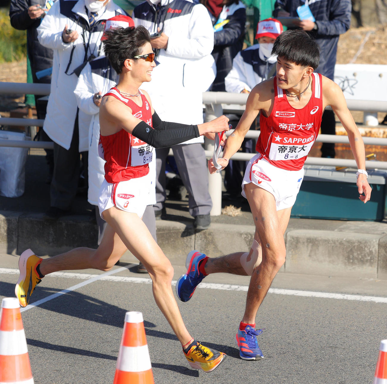 平塚中継所を4位でタスキリレーする帝京大7区福島（左）と8区橋本（撮影・河田真司）
