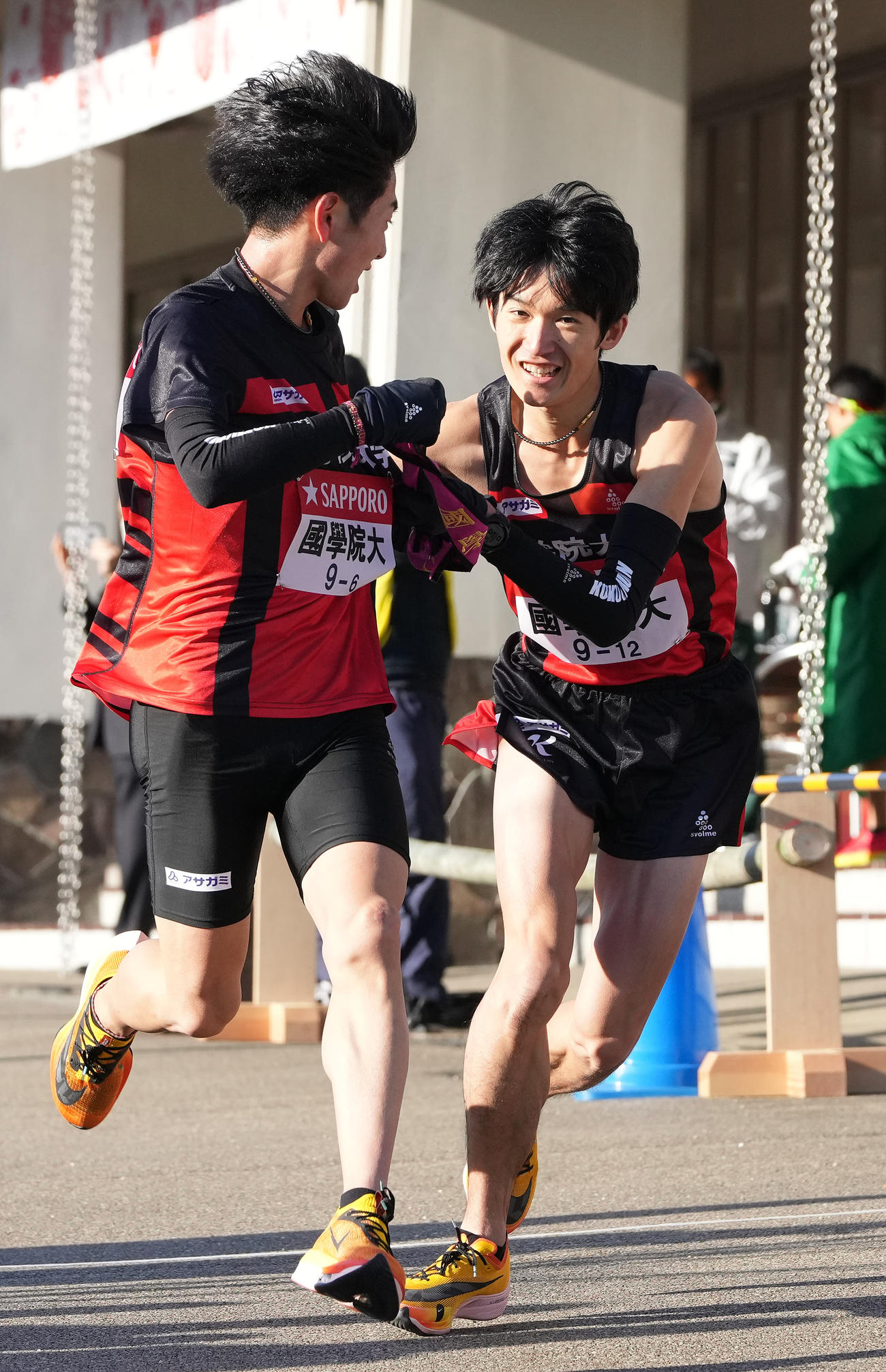 国学院大6区原（左）は小田原中継所で7区木付にたすきを渡す（撮影・鈴木みどり）