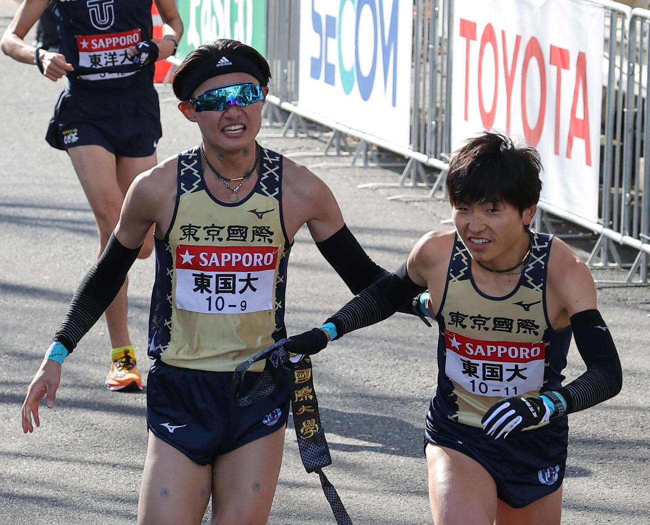 鶴見中継所、たすきをつなぐ東京国際大9区宗像（左）と10区野沢（撮影・河野匠）