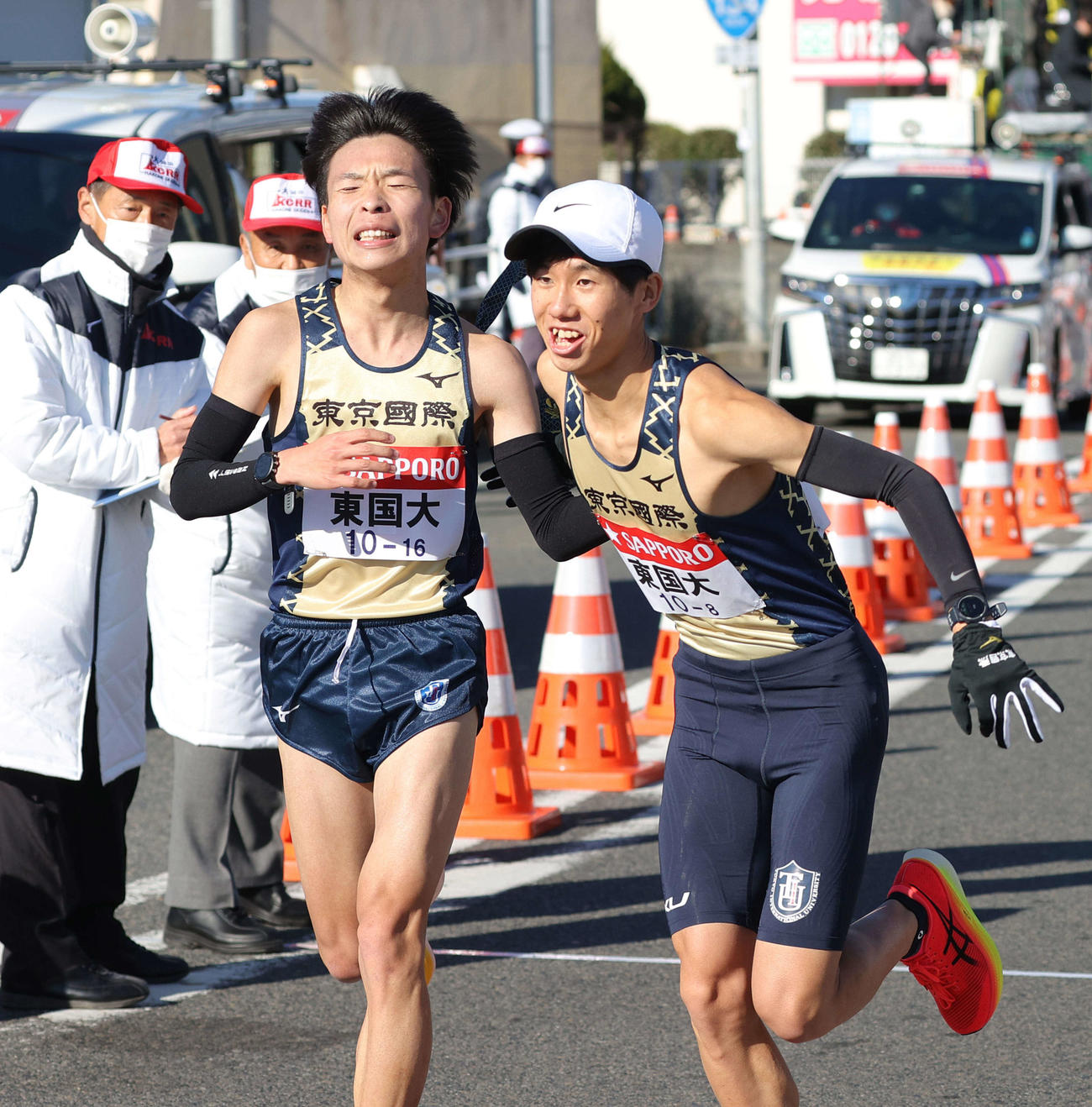東京国際大7区冨永（左）は平塚中継所で8区村松にたすきを渡す（代表撮影）