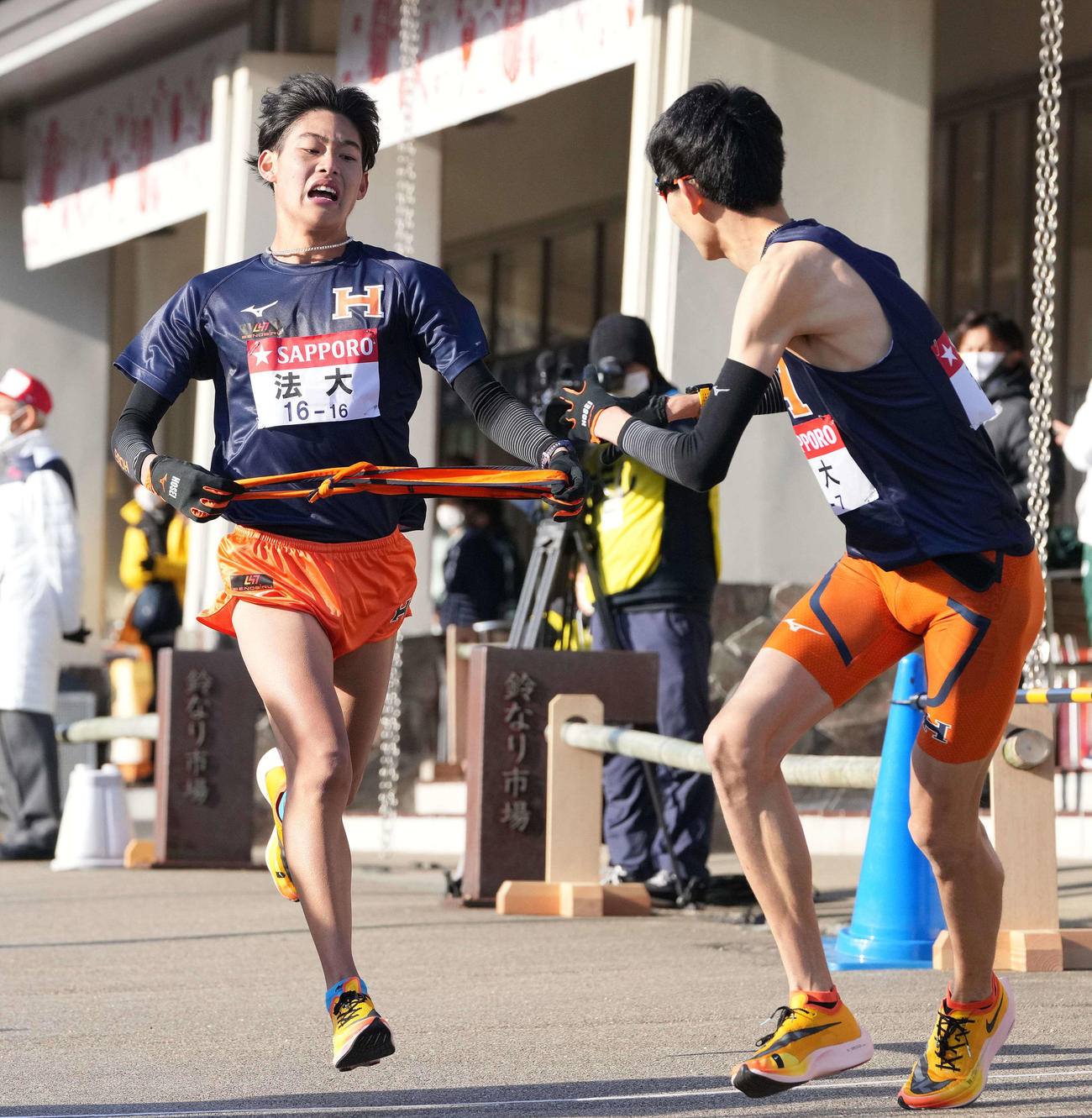 法大6区武田（左）は小田原中継所で7区中園にたすきを渡す（撮影・鈴木みどり）