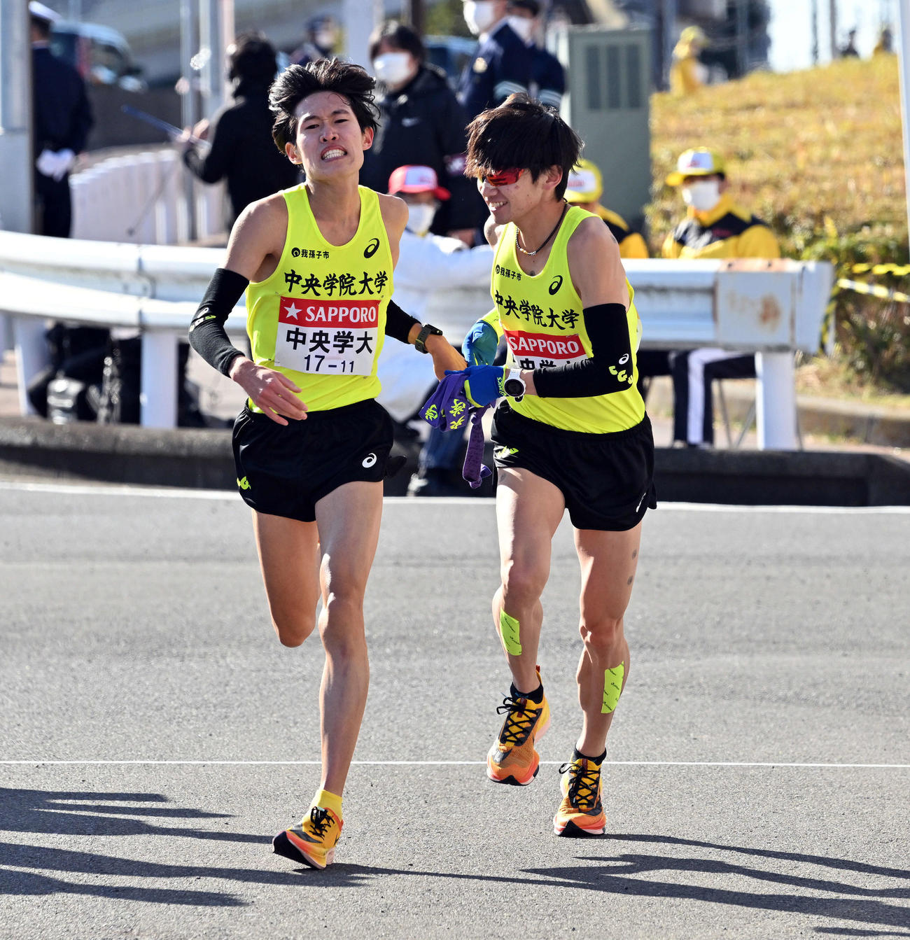 戸塚中継所で中央学院大8区馬場（左）は9区吉田光にたすきを渡す（撮影・滝沢徹郎）