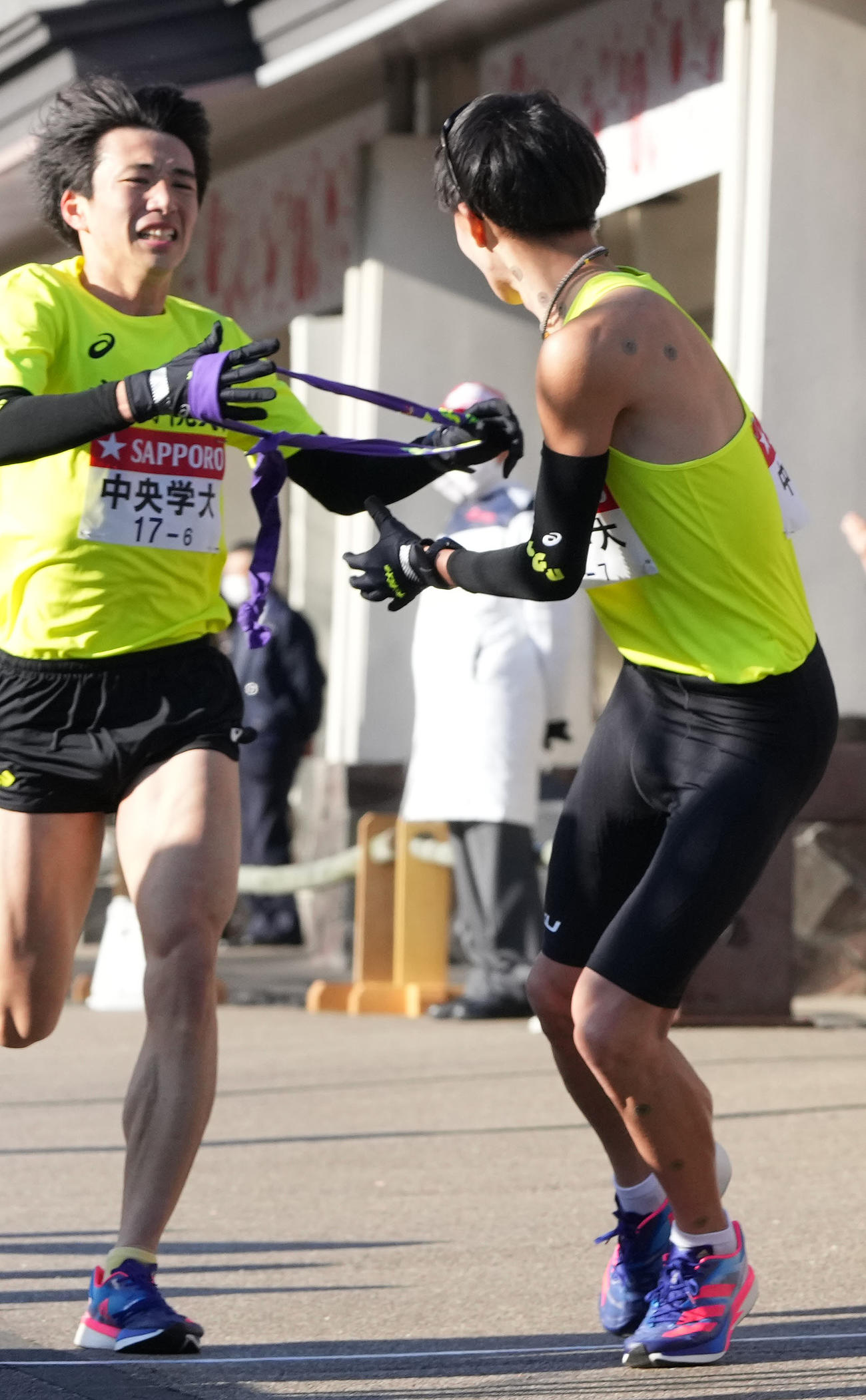 中央学院大6区工藤（左）は小田原中継所で7区松井にたすきを渡す（撮影・鈴木みどり）