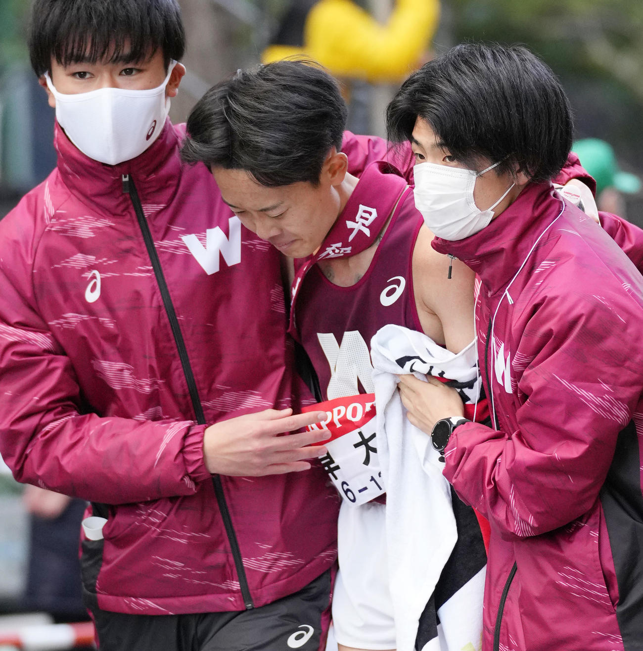 13位でゴールし、チームメイトに抱えられる早大10区山口（撮影・菅敏）