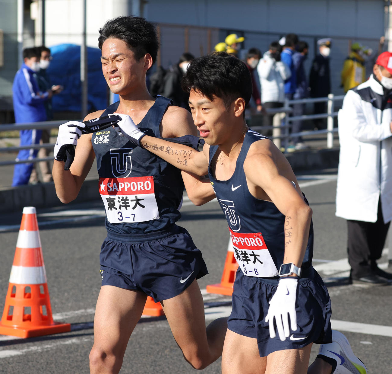 東洋大7区梅崎（左）は平塚中継所で8区蝦夷森にたすきを渡す（代表撮影）
