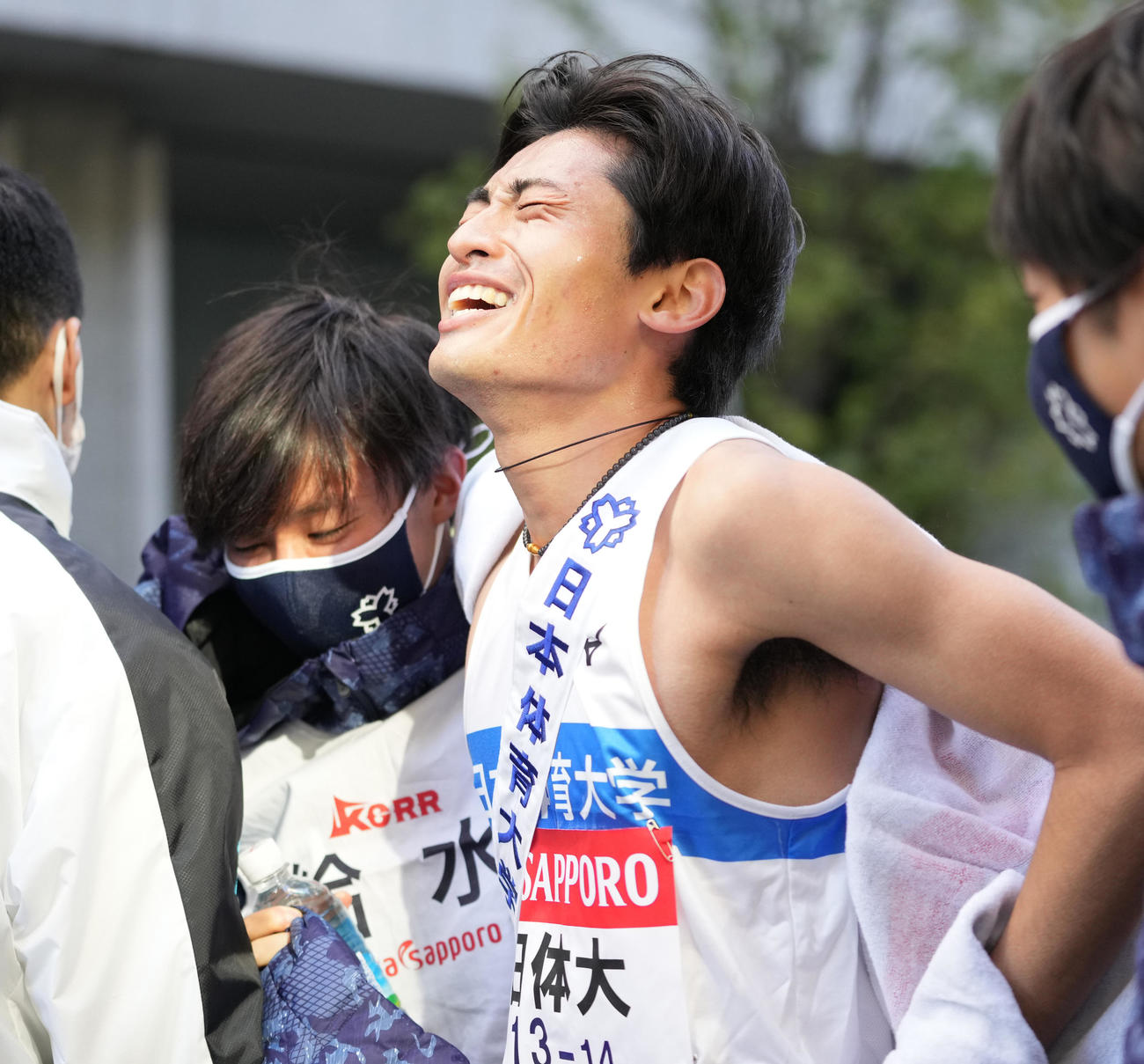 17位でゴールし、チームメートに抱えられる日体大10区佐藤（撮影・菅敏）