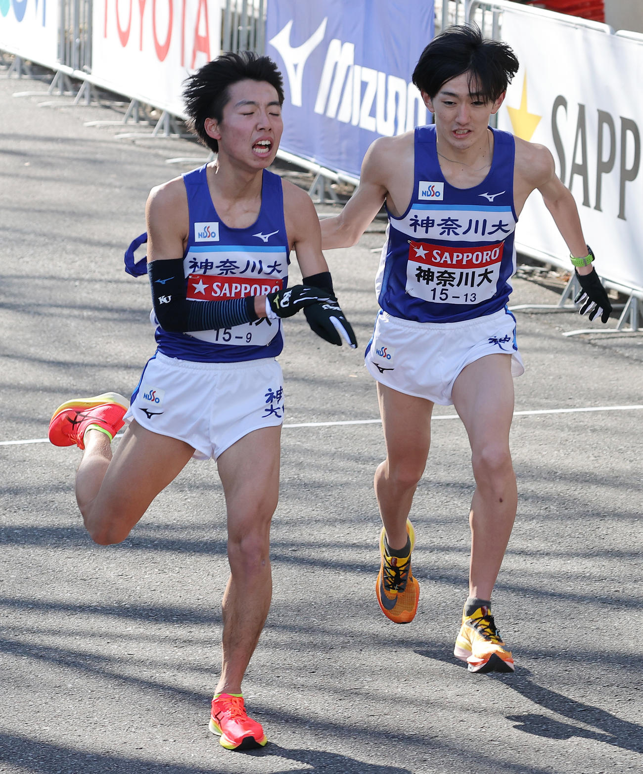 鶴見中継所、たすきをつなぐ神奈川大9区小林篤（左）と10区有村（撮影・河野匠）
