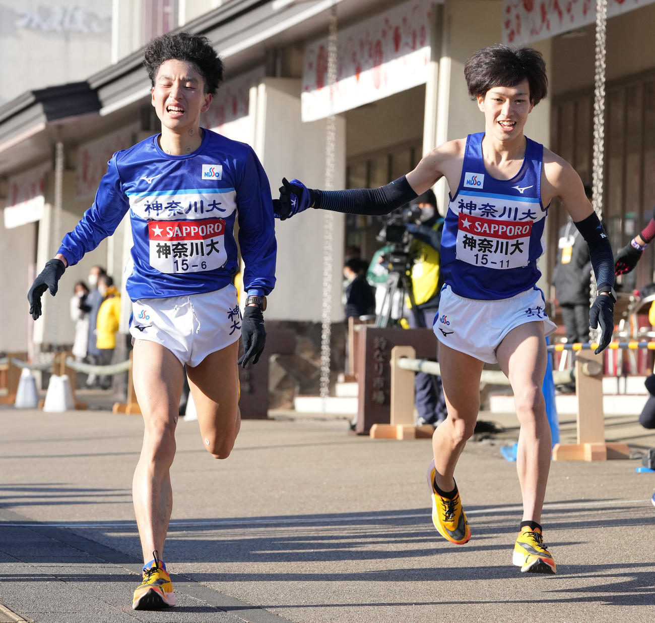 神奈川大6区横沢（左）は小田原中継所で7区川口にたすきを渡す（撮影・鈴木みどり）