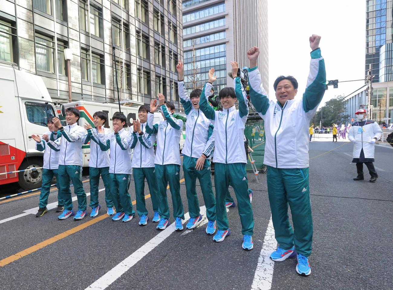 笑顔で手を上げ、10区中倉のゴールを待つ原監督（右）ら青学大の選手たち（代表撮影）