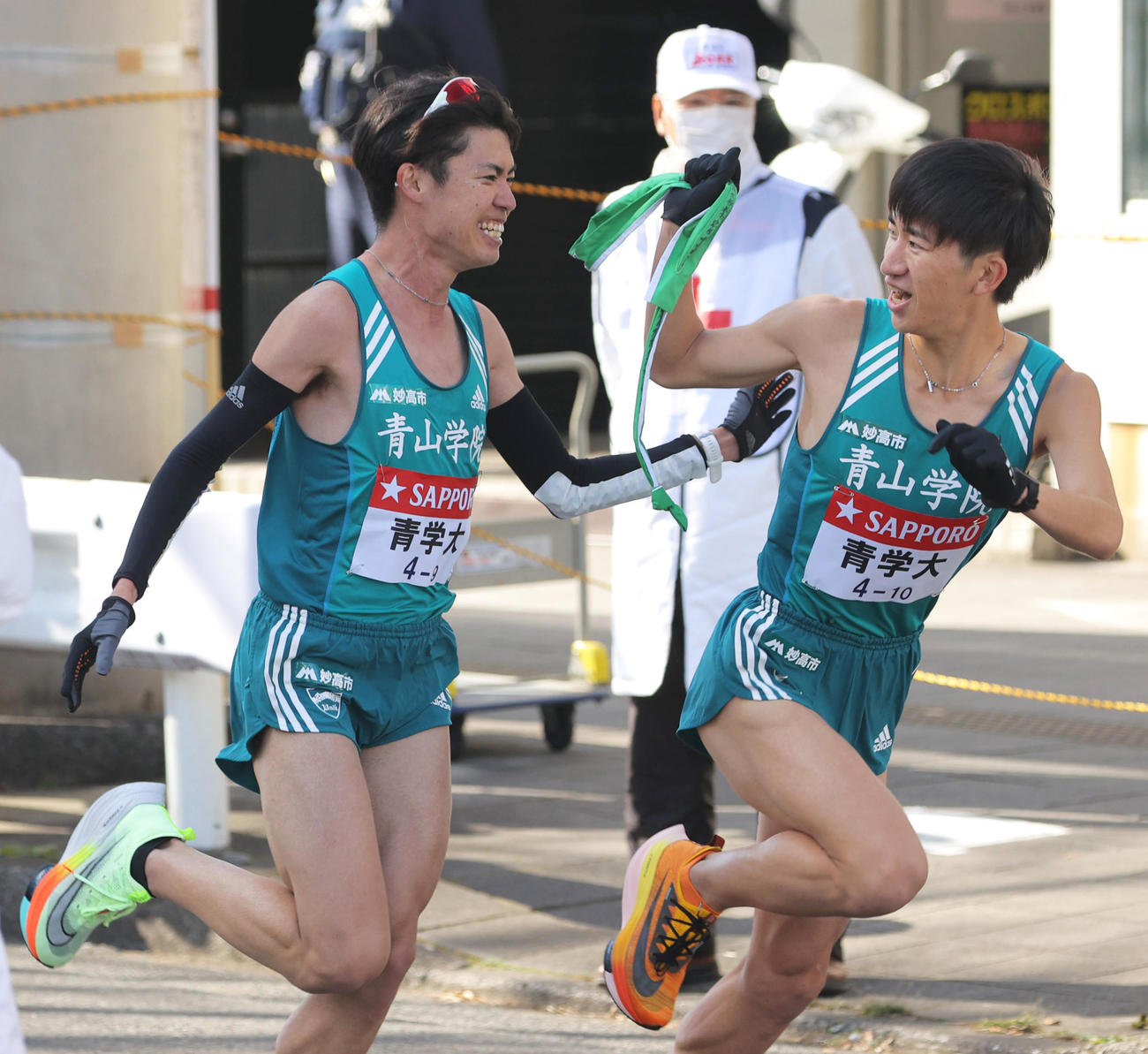 鶴見中継所で青学大9区中村（左）からタスキを受け取る10区中倉（代表撮影）