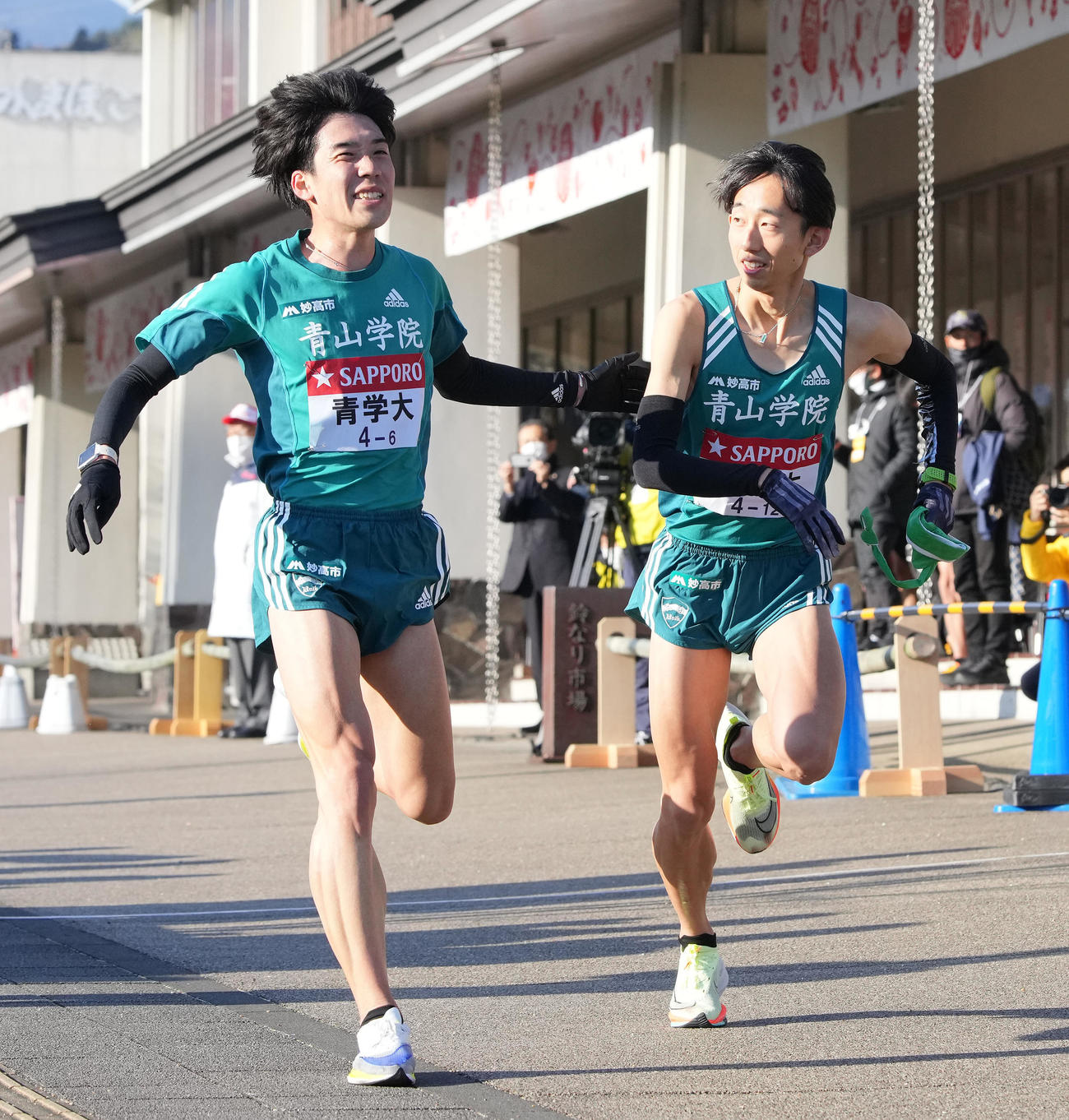 青学大6区高橋（左）は小田原中継所トップで7区岸本にたすきを渡す（撮影・鈴木みどり）