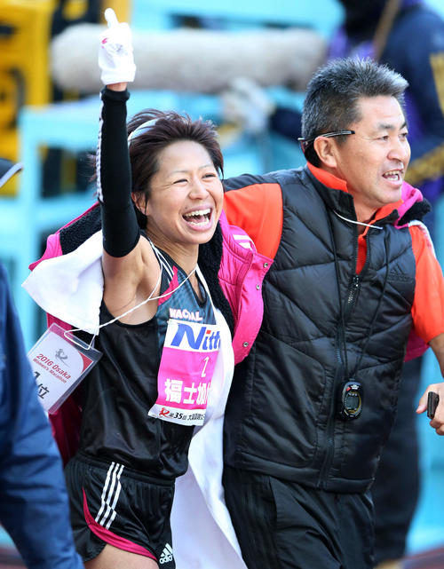 優勝し、笑顔で1番ポーズをとる福士。右は永山監督