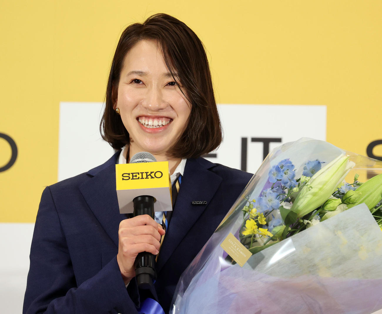 現役引退を発表した福島千里は花束を手に笑顔であいさつする（撮影・浅見桂子）