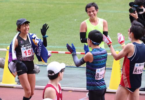 ハーフマラソンをゴールした福士（左）は男子選手の拍手の出迎えに笑顔を見せる（撮影・上田博志）