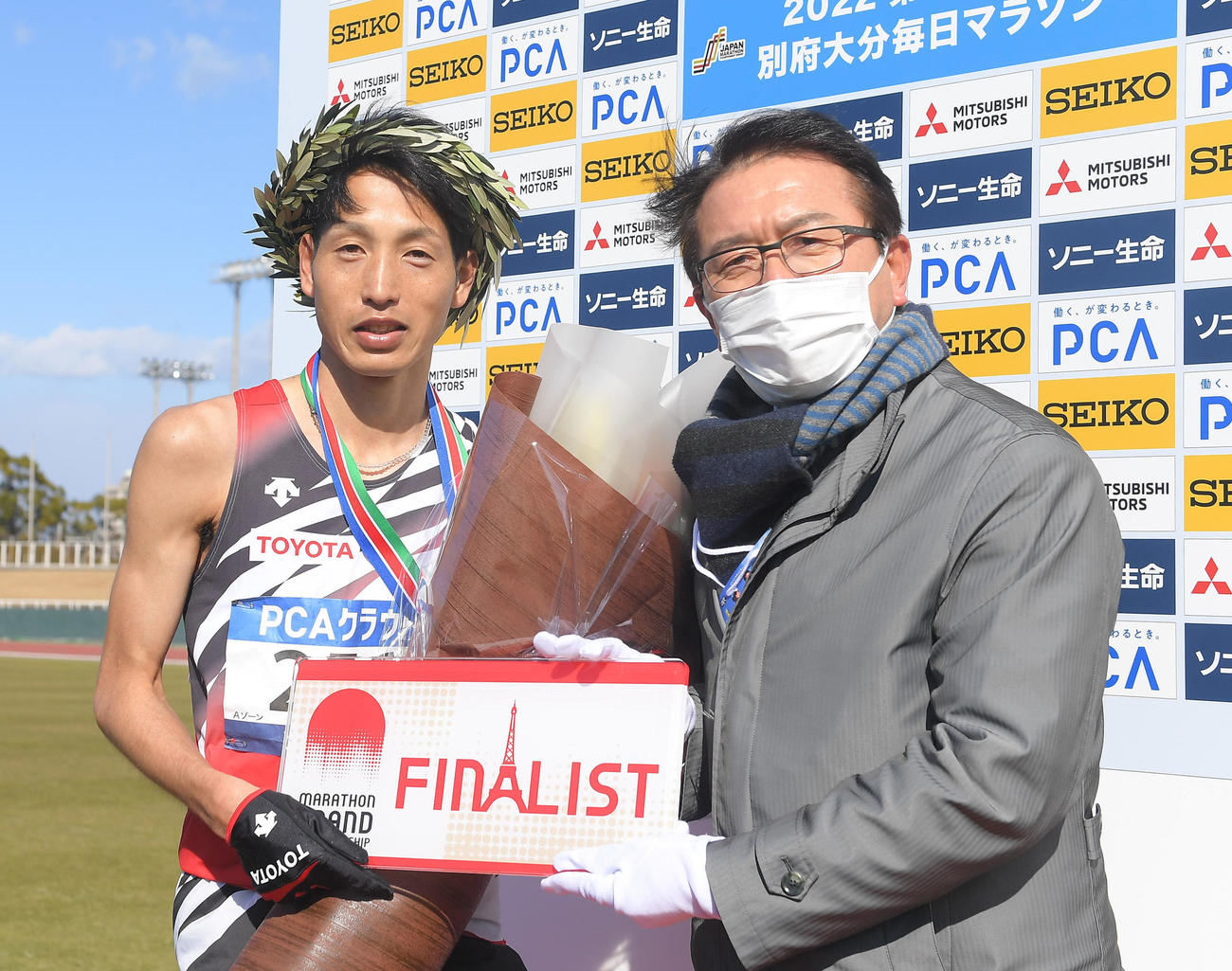 瀬古利彦・日本陸上競技連盟ロードランニングコミッションリーダー（右）からМGCチケットを渡される西山雄介（代表撮影）