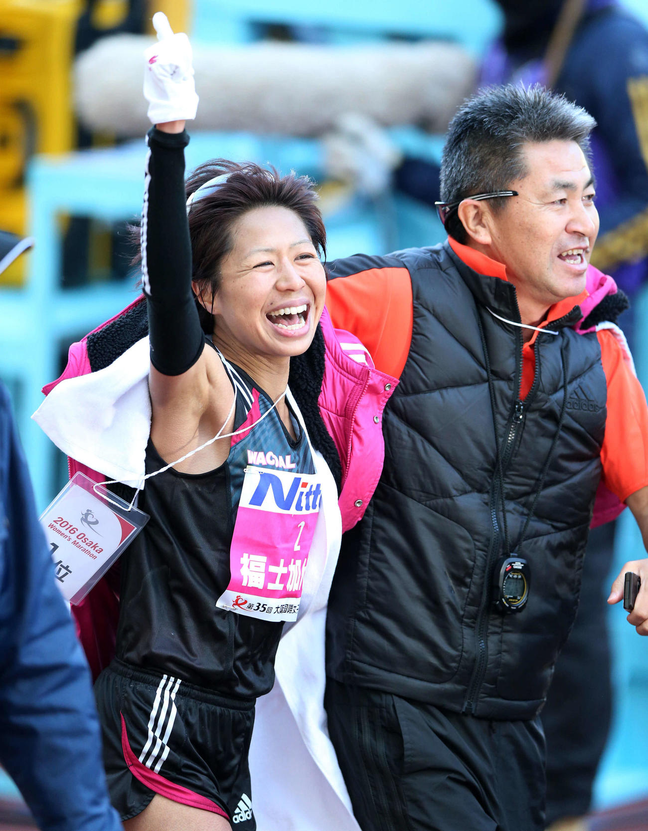 16年1月31日、大阪国際女子マラソンで優勝し、NO・1ポーズを決める福士。右は永山監督