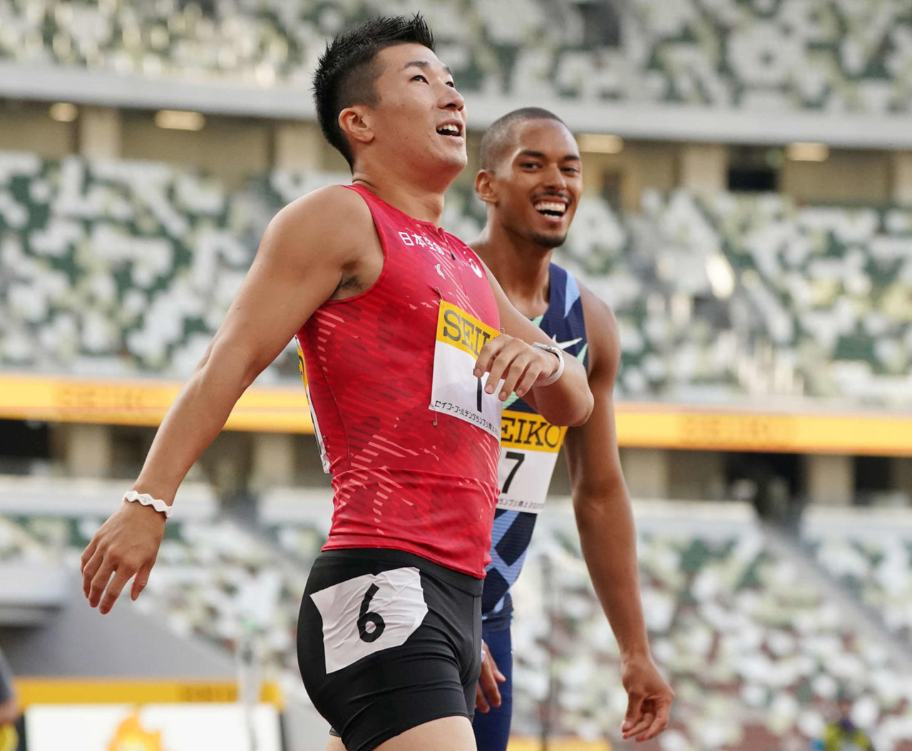 男子100メートル決勝で優勝した桐生（左）はゴール後に笑顔を見せる。右は2位のケンブリッジ