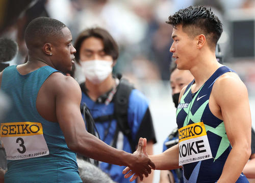 男子100メートルで優勝したコールマン（左）と握手をかわす2位の小池（撮影・狩俣裕三）