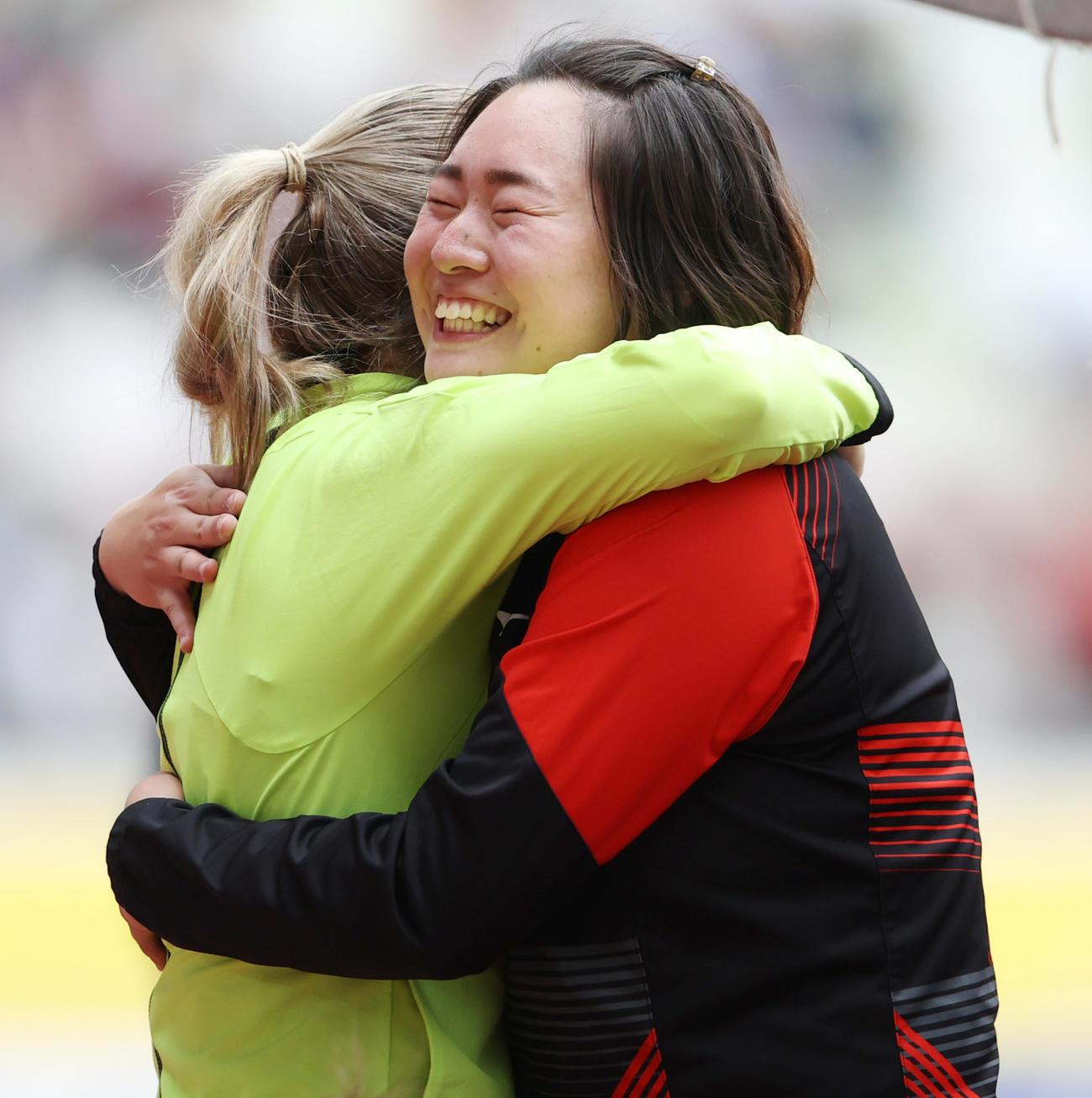 女子やり投げで優勝し、笑顔で海外選手と抱き合い喜ぶ北口（撮影・狩俣裕三）